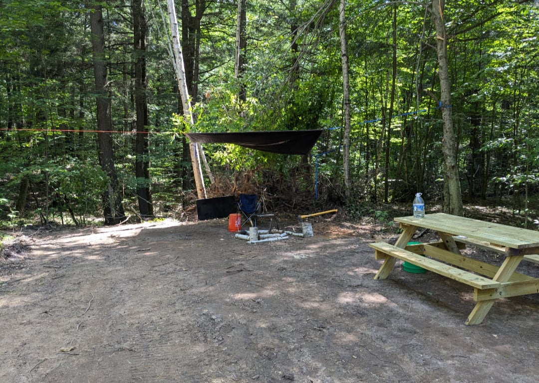 Picnic table and shade tarp at the primitive campsite clearing
