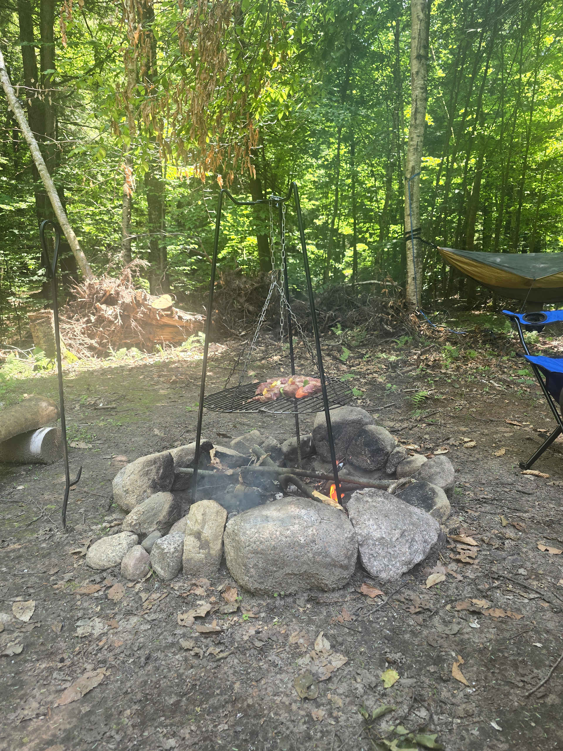 Kebabs cooking on the provided tripod grill over the campfire