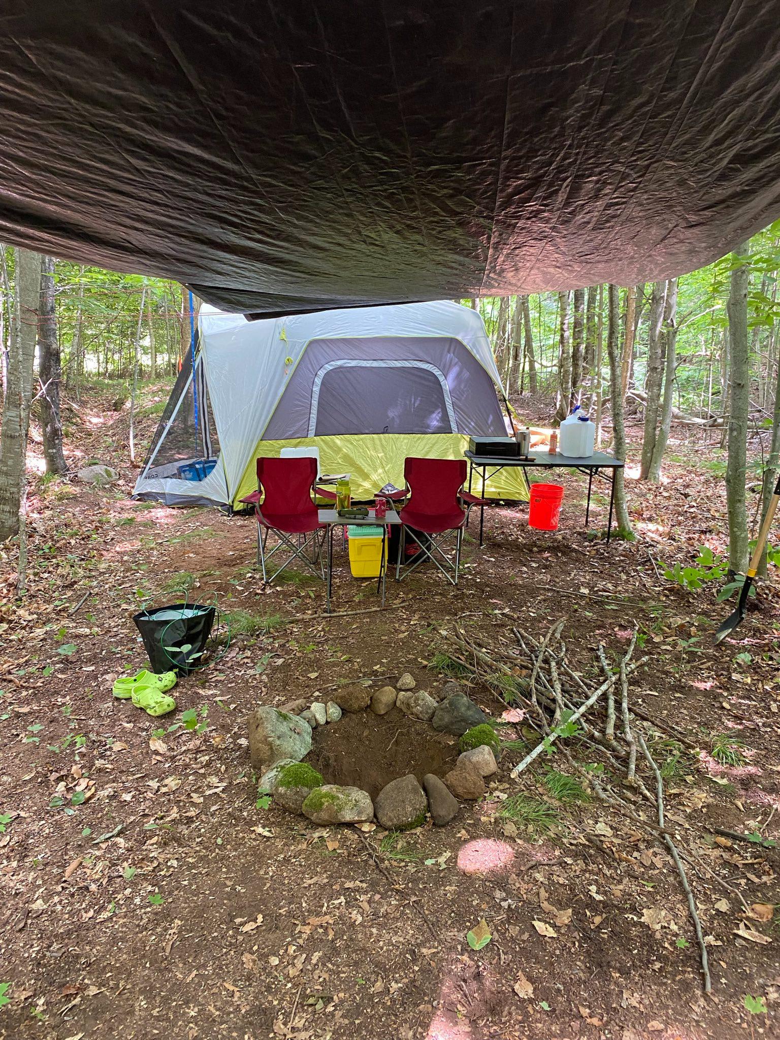 Tent and camp kitchen set up under a tarp for a weekend of primitive camping
